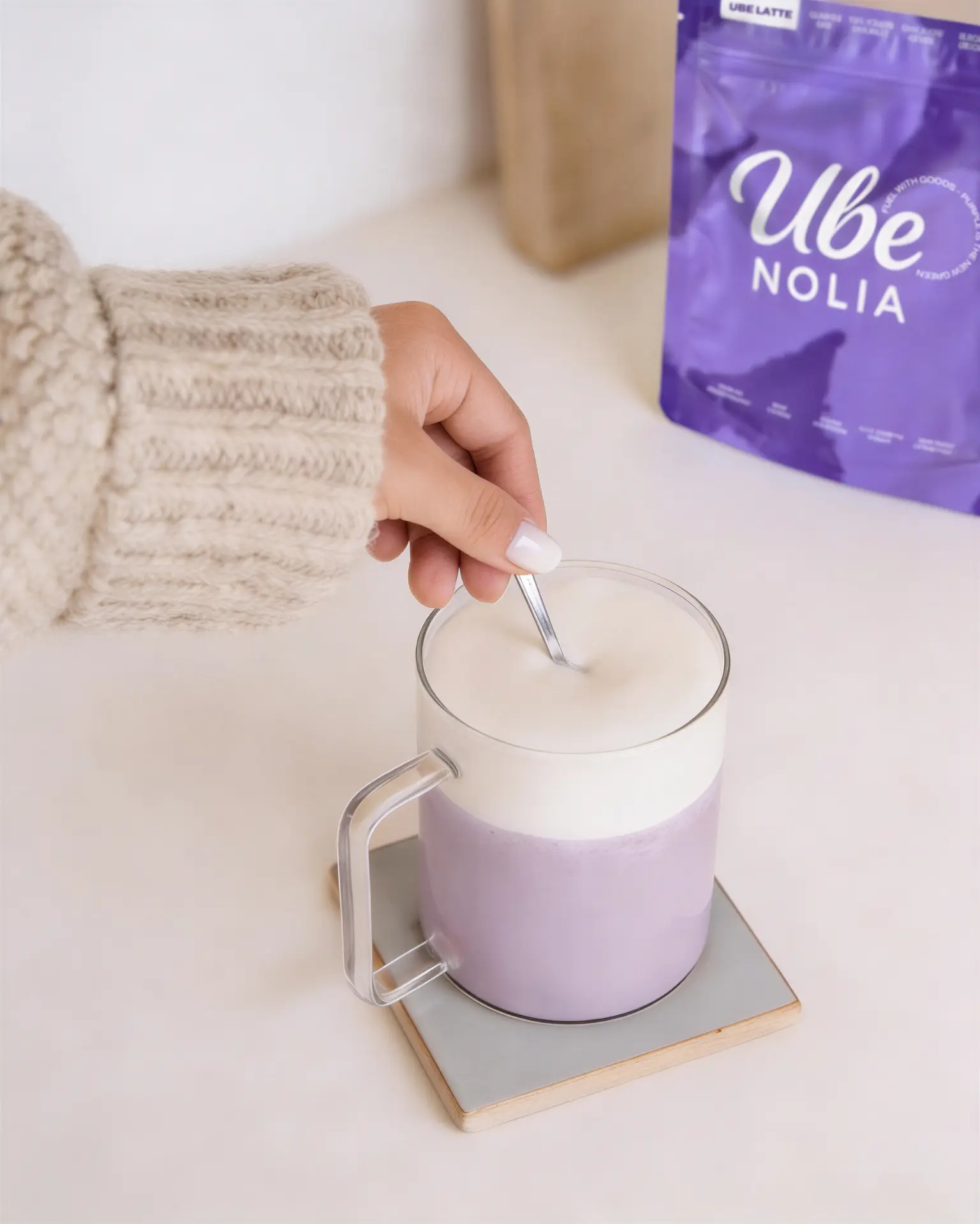 Ube Latte van Ube Nolia wordt geroerd naast de zak ube poeder
