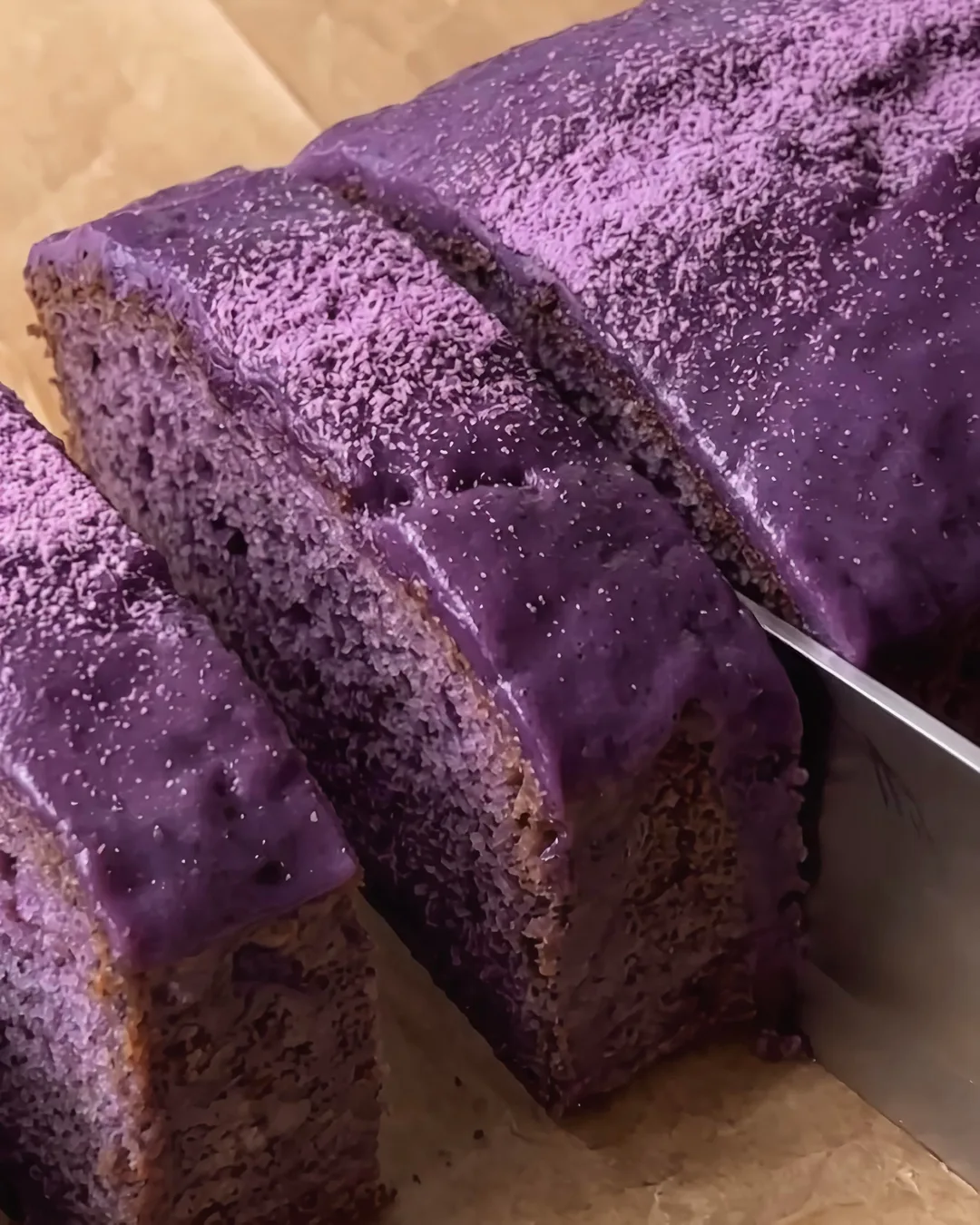 Aangesneden ube-banana cake met glanzende ube-glazuur | Ube Nolia