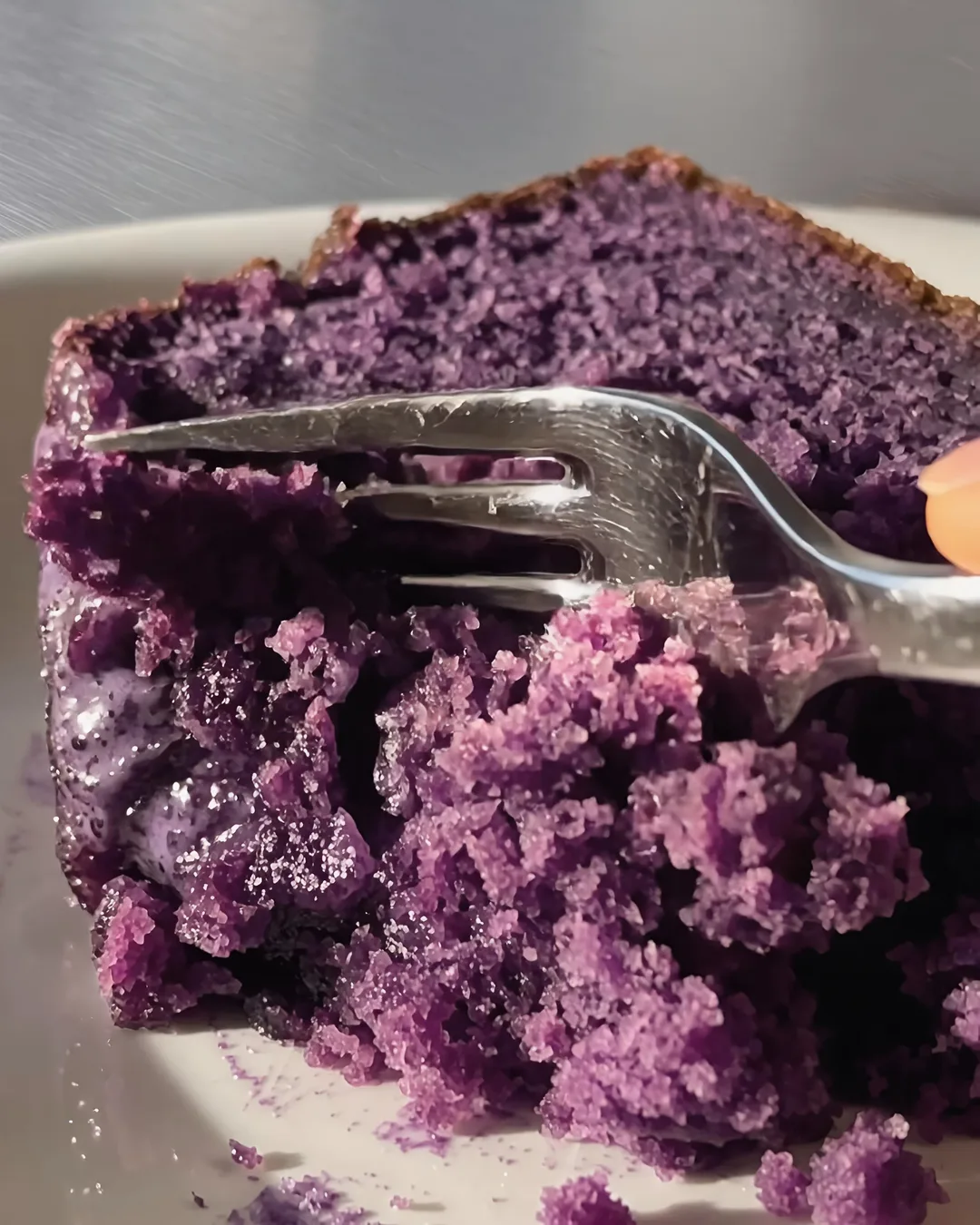 Vork snijdt in een sappige plak ube-banana cake | Ube Nolia